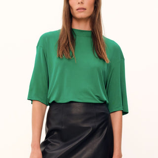The grass green Aphrodite Top is constructed with luxurious silk viscose jersey, creating a relaxed tee silhouette with a high, round neckline. The silk knit fabric drapes with effortless grace.