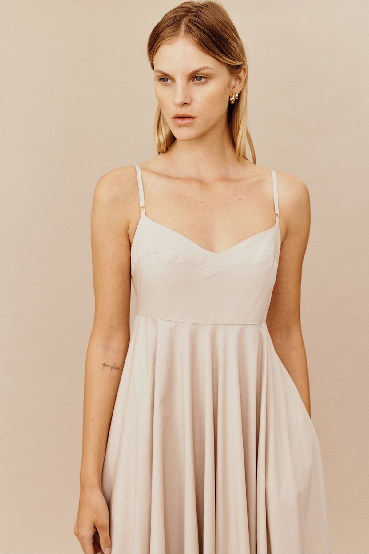 Model wearing Australian women's fashion Designer GINGER & SMARTS' pebble beige organic cotton Believer Maxi Sundress featuring rolling hem with undulated length, Deep pockets, and delicately tailored bodice with fine adjustable straps.