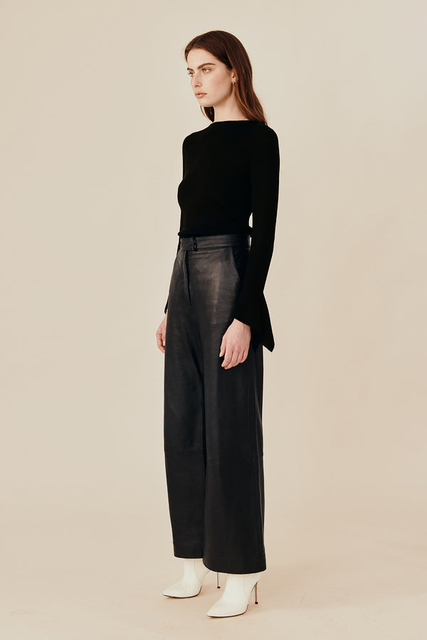 Side view of Model wearing Australian fashion designer Ginger & Smarts’ Genesis Leather Pant in a classic straight leg cut in luxe black leather worn with the black wool Dimension Knit Top.