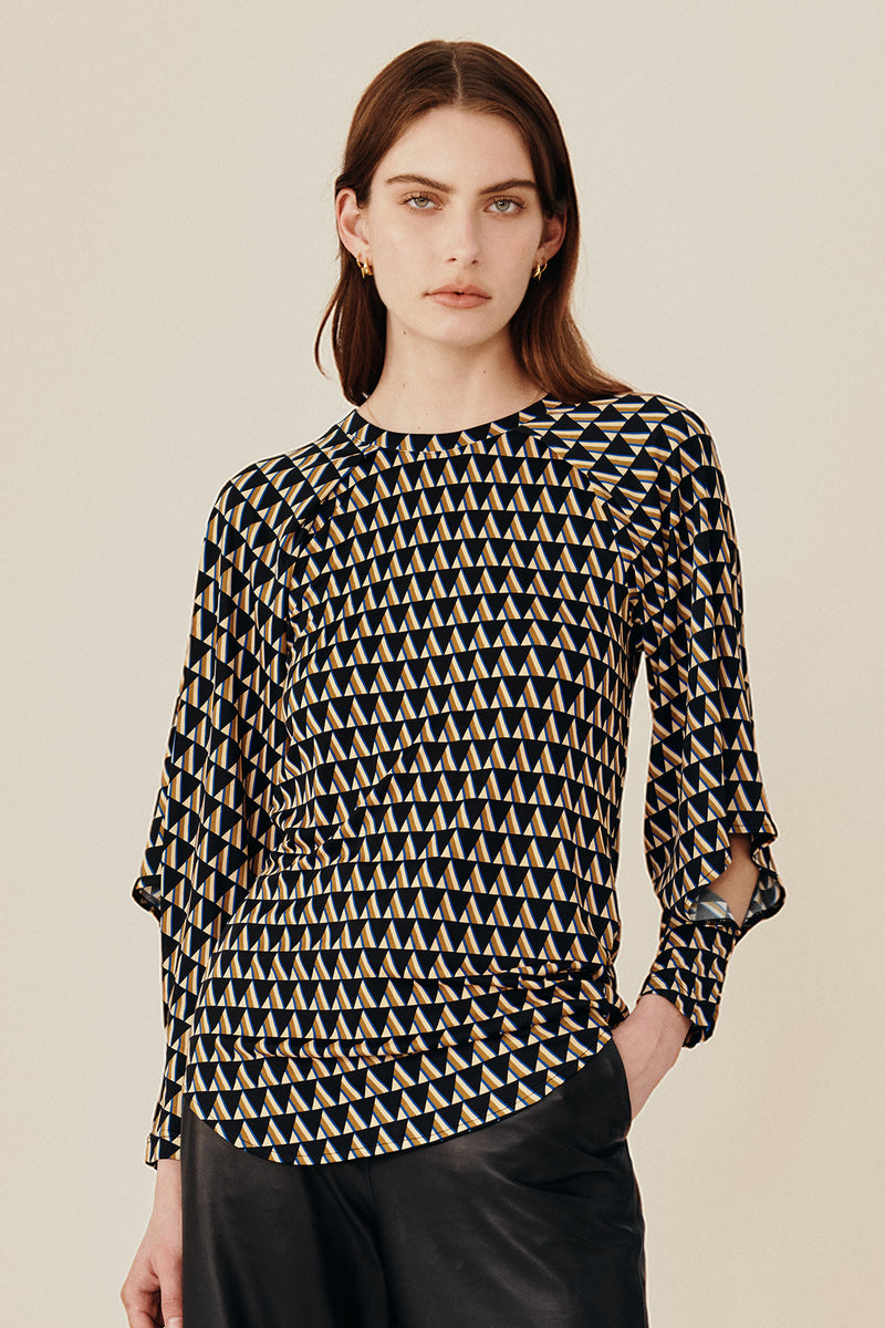 Australian luxury fashion designer GINGER & SMARTS' women's geometric printed silk long sleeve top with a crew neck and angular sleeve. Worn on a model with the women's black Genesis Leather Pant