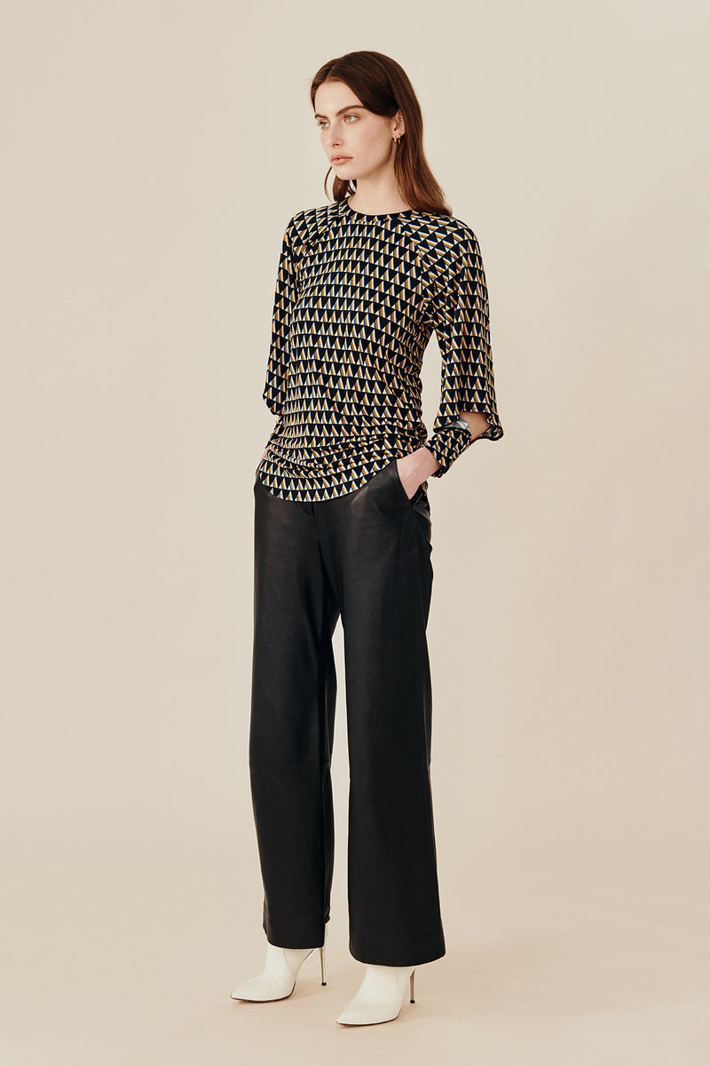 Australian luxury fashion designer GINGER & SMARTS' women's geometric printed silk long sleeve top with a crew neck and angular sleeve. Worn on a model with the women's black Genesis Leather Pant