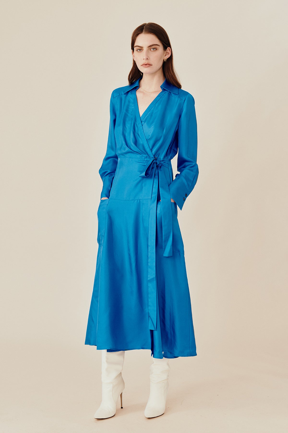 Model wearing Australian fashion designer GINGER & SMARTS' blue silk Libertine that is the classic wrap silhouette that features a sharp collar and gently flared skirt with a long shirt sleeve.  