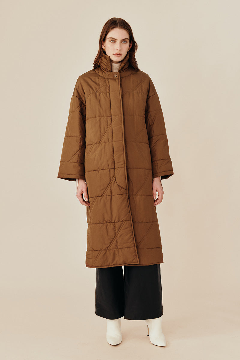 Model wearing the Australian luxury fashion designer GINGER & SMARTS' brown Sterling Quilted Coat featuring quilt detailing, lightweight design and is knee length.Worn with the women's black Genesis Leather Pant and Oatmeal Dimension Knit