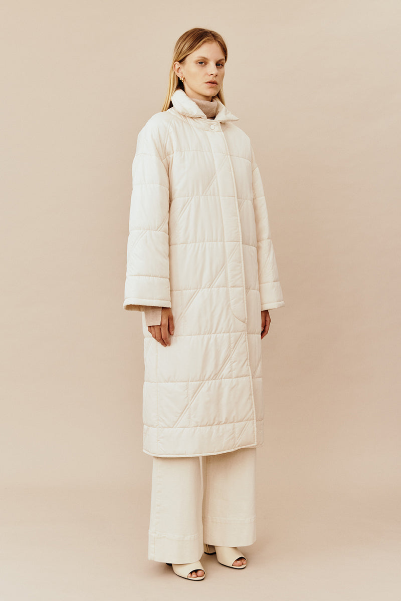 Model wearing the Australian luxury fashion designer GINGER & SMARTS' cream Sterling Quilted Coat featuring quilt detailing, lightweight design and is knee length. Worn with the wide leg cream Annie Jeans.