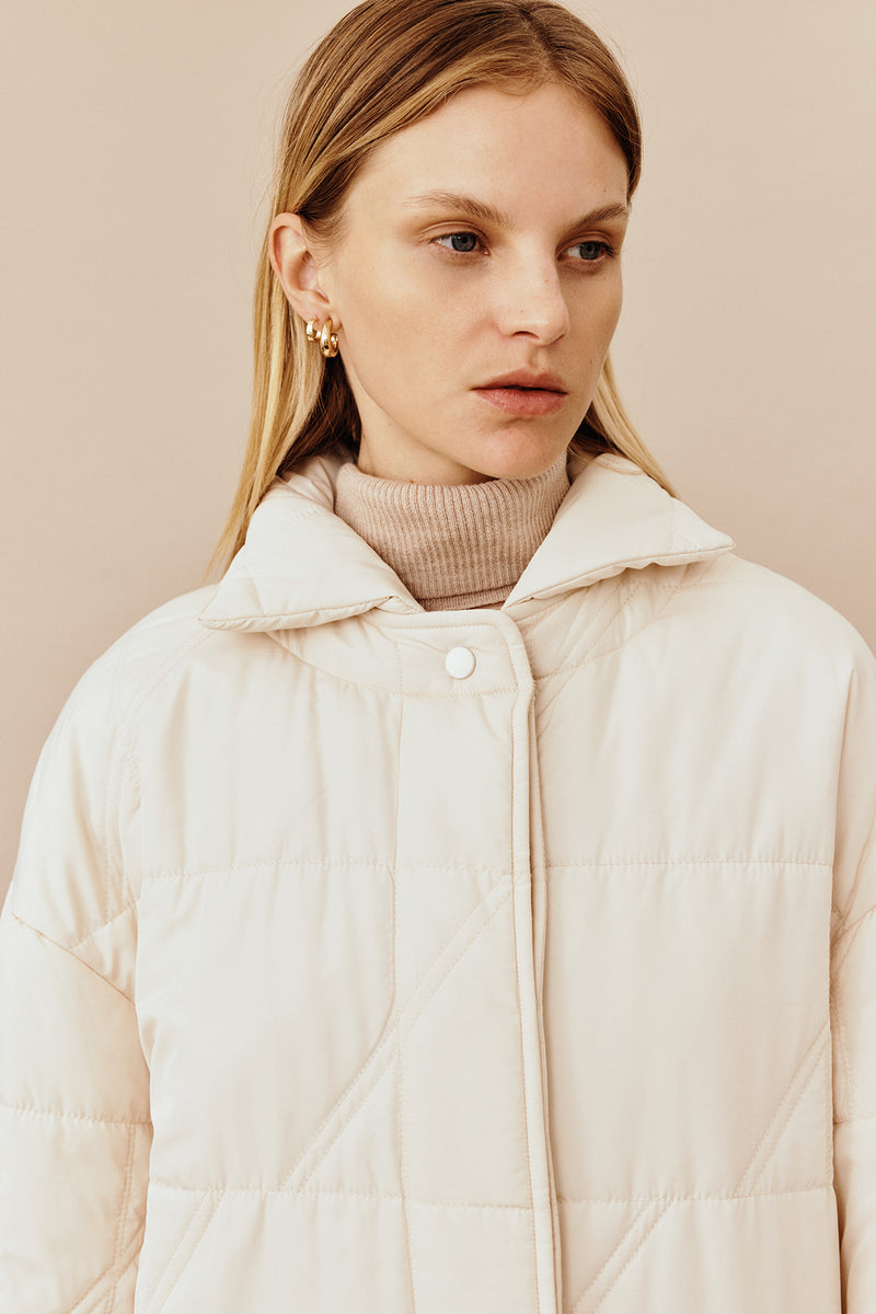 Model wearing the Australian luxury fashion designer GINGER & SMARTS' cream Sterling Quilted Coat featuring quilt detailing, lightweight design and is knee length. Worn with the wide leg cream Annie Jeans.