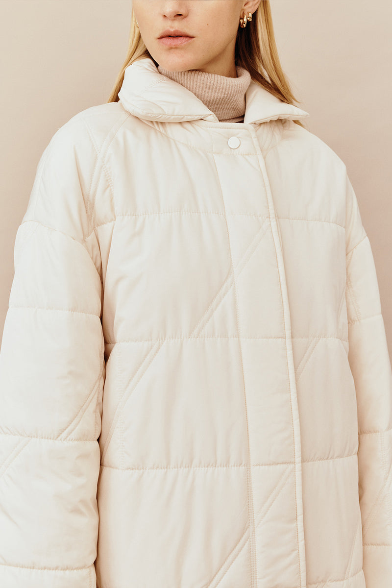 Model wearing the Australian luxury fashion designer GINGER & SMARTS' cream Sterling Quilted Coat featuring quilt detailing, lightweight design and is knee length. Worn with the wide leg cream Annie Jeans.