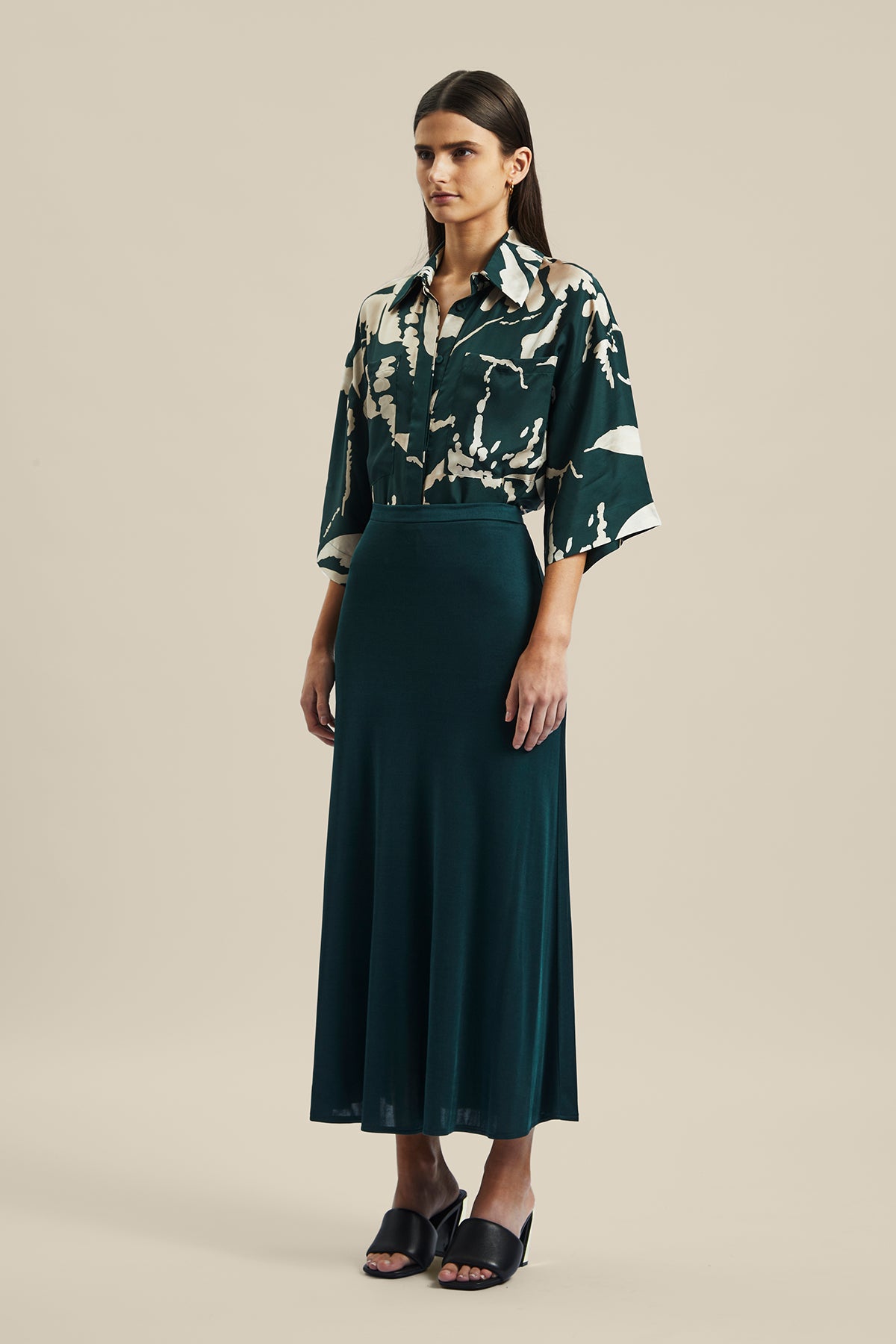 Model wearing the forest green silk Coalesce Skirt from Australian fashion designer Ginger & Smart. Worn with the Memoirs Blouse