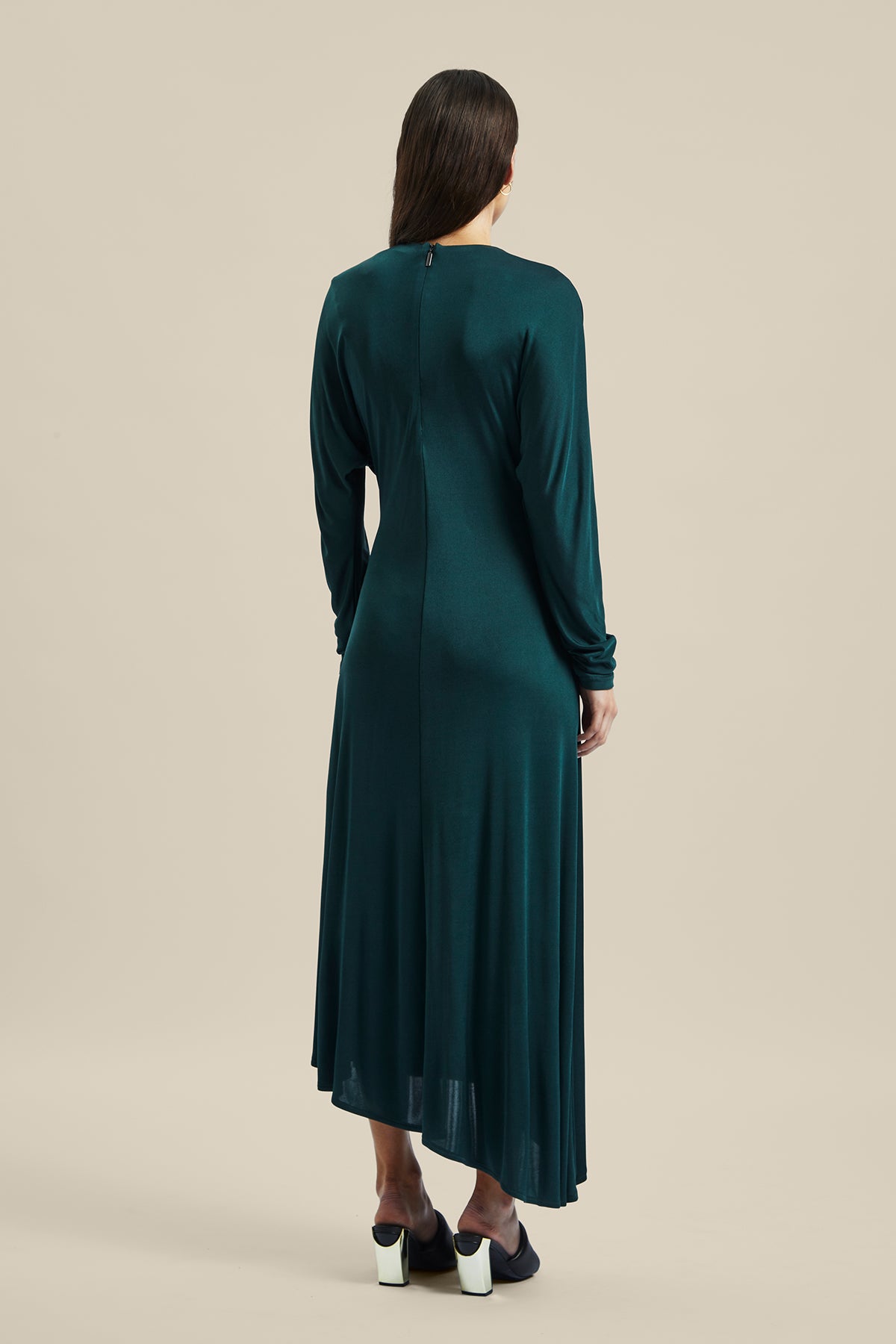 Back view of a Model wearing the forest green silk Coalesce Twist Front Dress from Australian women’s designer Ginger and Smart featuring bias cut, cut out derail above the collarbone and midi length.