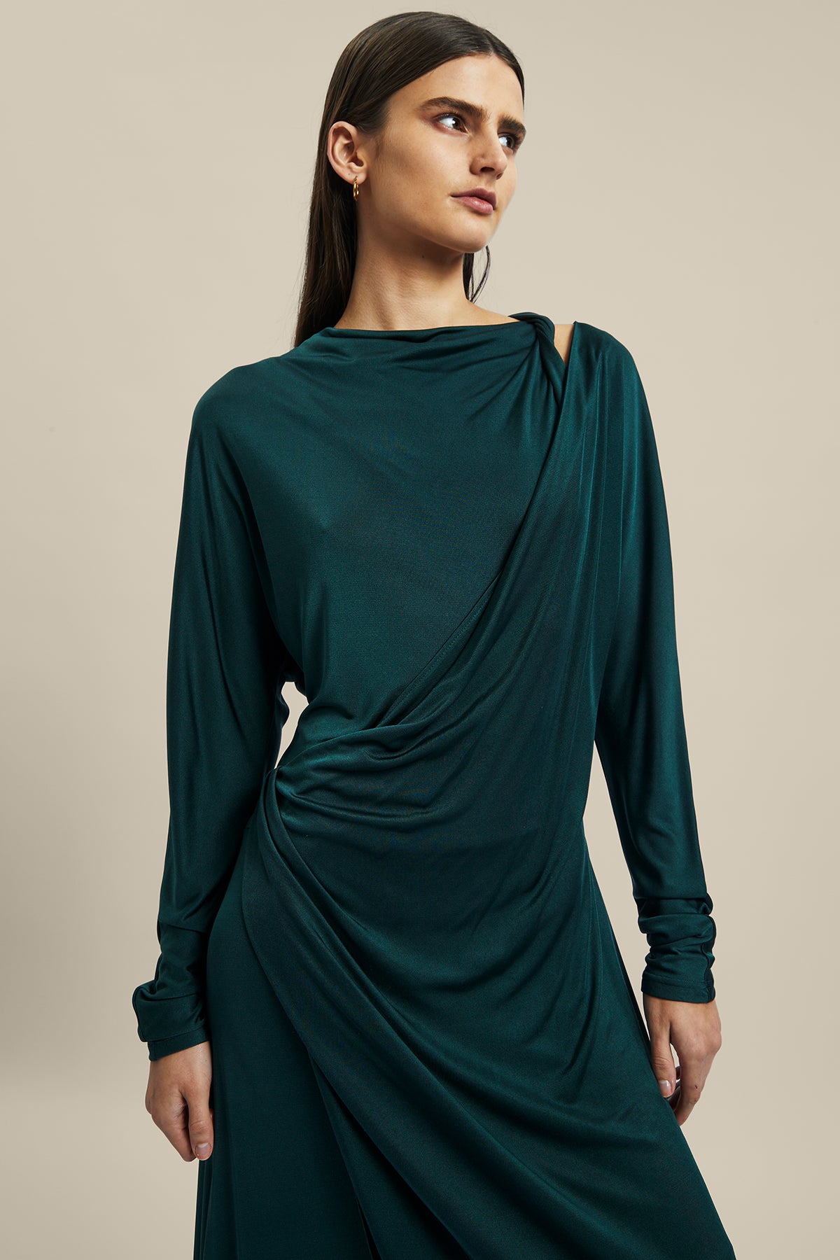 Model wearing the forest green silk Coalesce Twist Front Dress from Australian women’s designer Ginger and Smart featuring bias cut, cut out derail above the collarbone and midi length.