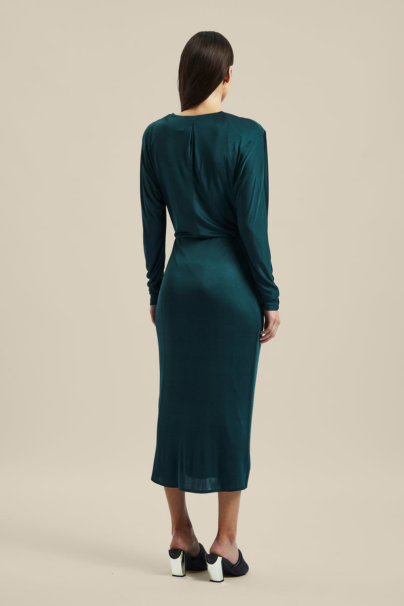 Back view of a Model wearing the green forest silk Coalesce Wrap Dress from Ginger & Smart featuring a waist tie with a v-neckline and midi length.