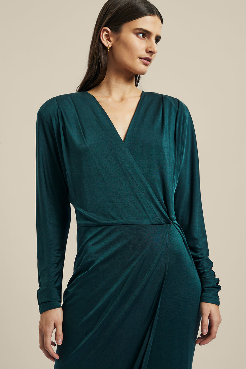 Model wearing the green forest silk Coalesce Wrap Dress from Ginger & Smart featuring a waist tie with a v-neckline and midi length.