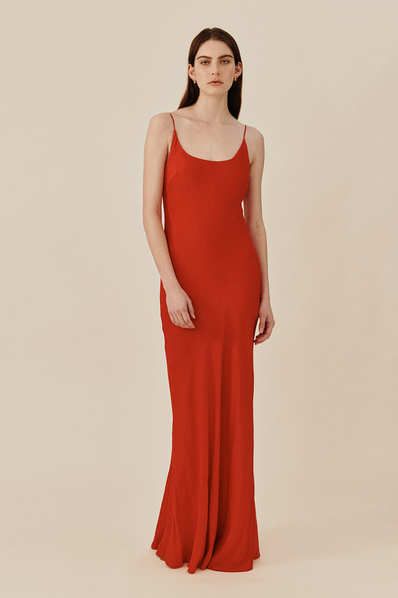 Model wearing 90’s inspired red Nocturnal Slip Dress from Australian luxury women’s designer GINGER & SMART, featuring body skimming fit, spaghetti straps, scoop neckline detail, maxi length, and a bias-cut skirt.