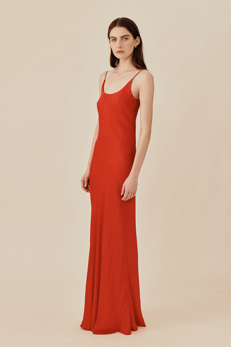 Model wearing 90’s inspired red Nocturnal Slip Dress from Australian luxury women’s designer GINGER & SMART, featuring body skimming fit, spaghetti straps, scoop neckline detail, maxi length, and a bias-cut skirt.