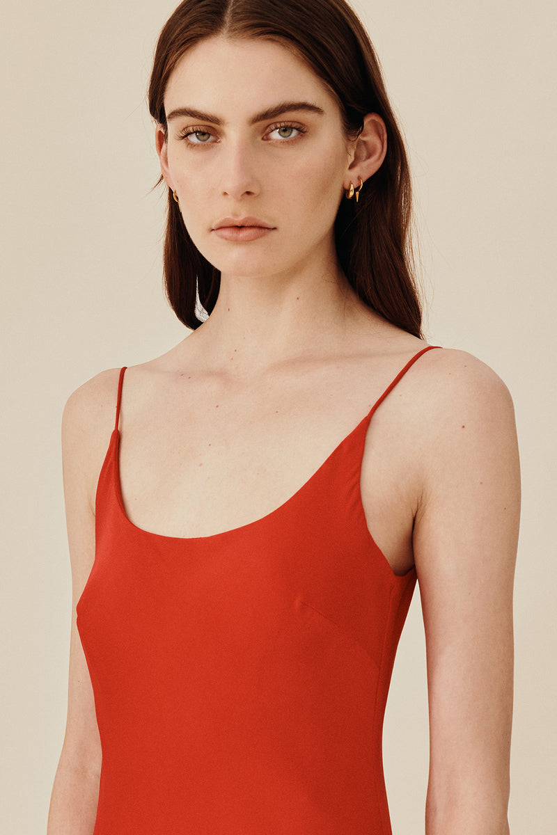 Model wearing 90’s inspired red Nocturnal Slip Dress from Australian luxury women’s designer GINGER & SMART, featuring body skimming fit, spaghetti straps, scoop neckline detail, maxi length, and a bias-cut skirt.