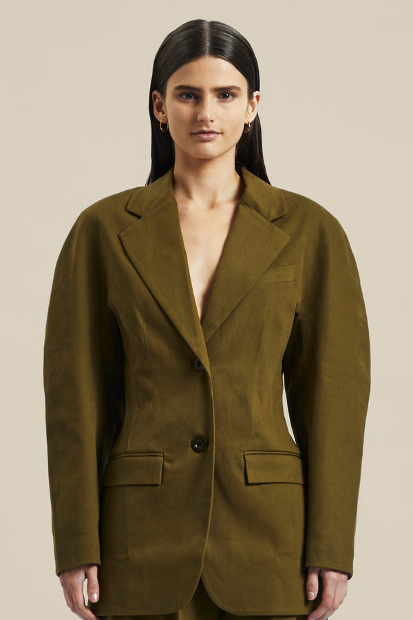 Model wearing the olive green Novelist Jacket from Australian fashion designer GINGER & SMART featuring, tailored structural cut and oversized shape. Worn with the olive green Novelist Pant.