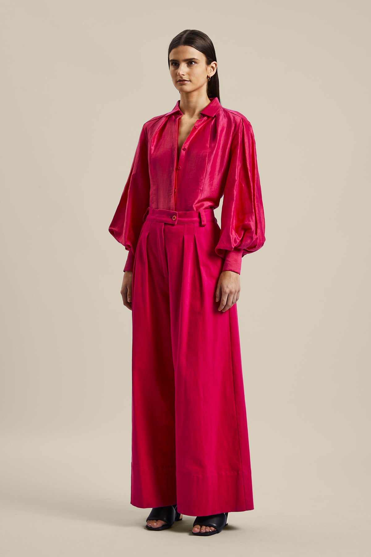 Model wearing the Novelist Pant from Australian women’s designer GINGER & SMART featuring a wide leg and sharp tailoring. Worn with a pink blouse.