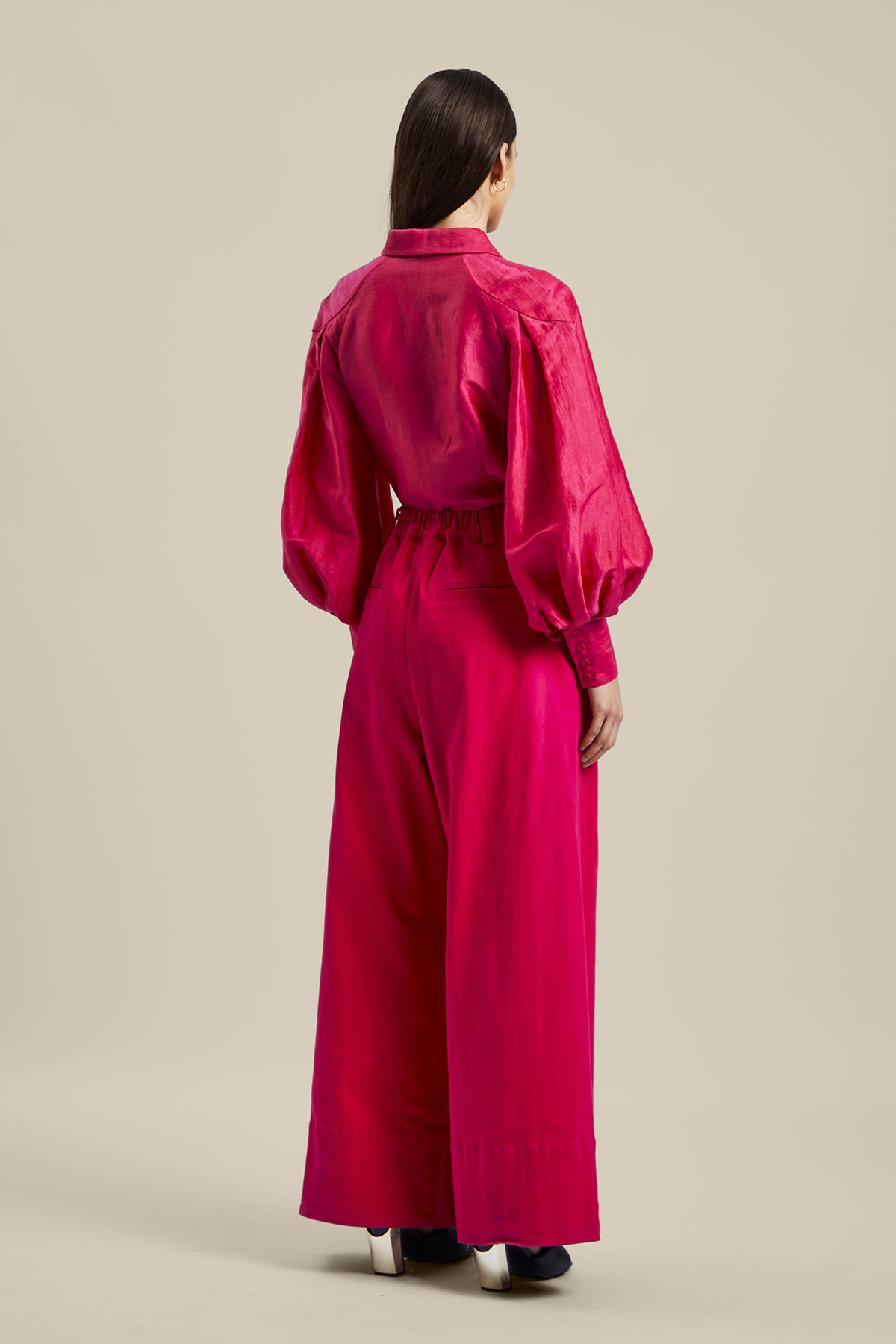 Back view of model wearing the Novelist Pant from Australian women’s designer GINGER & SMART featuring a wide leg and sharp tailoring. Worn with a pink blouse.