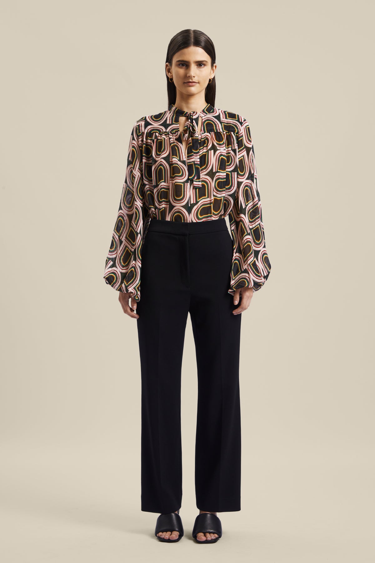 Model wearing the black women’s Rhetoric Pant from Australian Fashion Designer GINGER & SMART, featuring a slim fit, cropped straight leg with side pockets. Worn with the Kinship Blouse.
