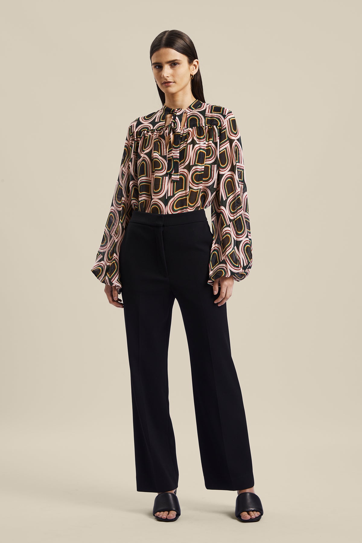 Model wearing the black women’s Rhetoric Pant from Australian Fashion Designer GINGER & SMART, featuring a slim fit, cropped straight leg with side pockets. Worn with the Kinship Blouse.