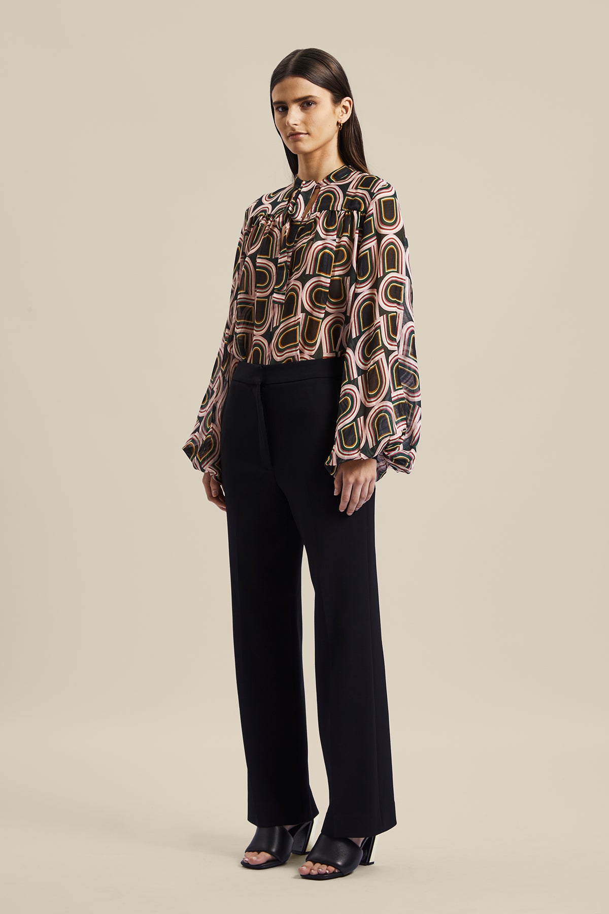 Model wearing the black women’s Rhetoric Pant from Australian Fashion Designer GINGER & SMART, featuring a slim fit, cropped straight leg with side pockets. Worn with the Kinship Blouse.