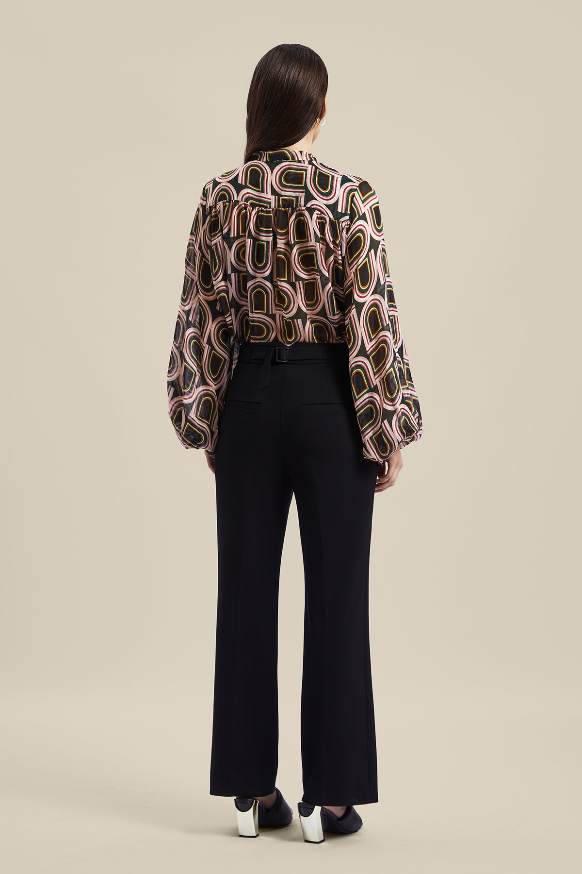 Back view of a model wearing the black women’s Rhetoric Pant from Australian Fashion Designer GINGER & SMART, featuring a slim fit, cropped straight leg with side pockets. Worn with the Kinship Blouse.